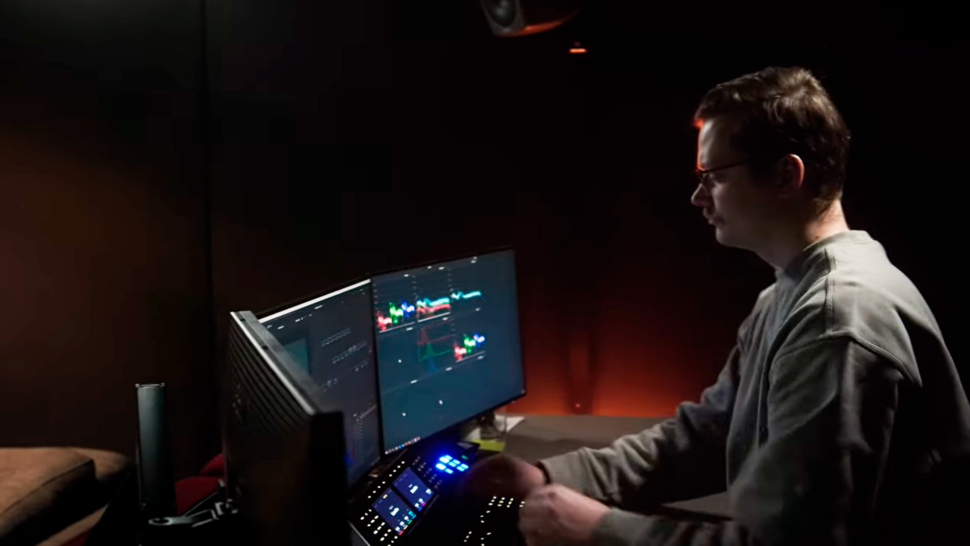 person_sitting_at_computer_in_dark_room_editing_video_footage