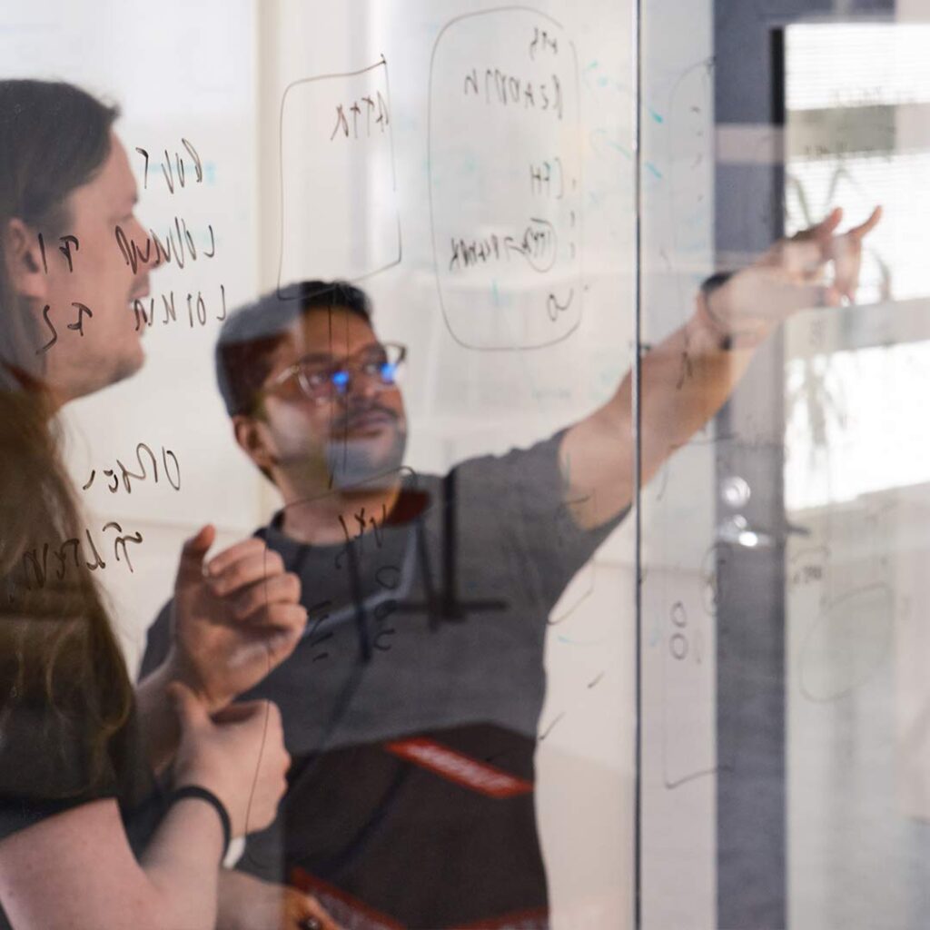 Tuxera engineers writing on a glass wall